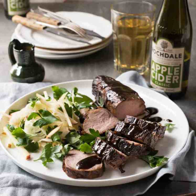 A plate of Apple Cider Glazed Pork Tenderloin with cutlery