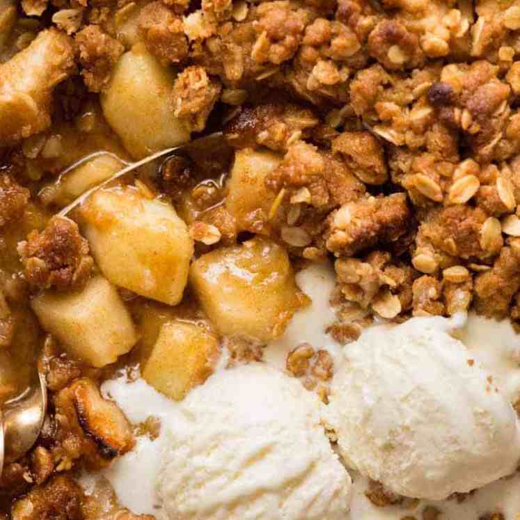 Close up overhead photo of Apple Crumble with scoops of vanilla ice cream