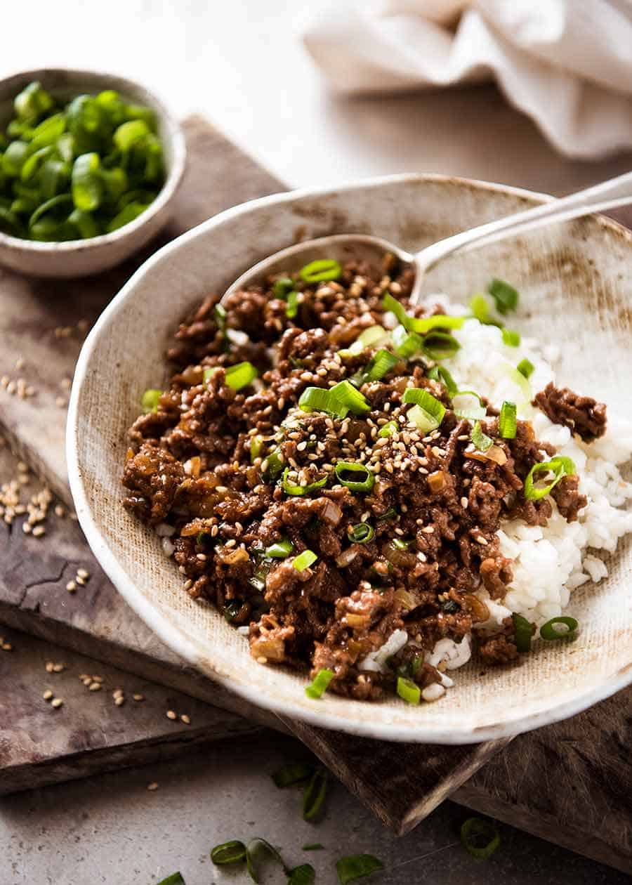 Asian Beef Bowls (ground beef recipe) served over rice garnished with scallions, ready to be eaten