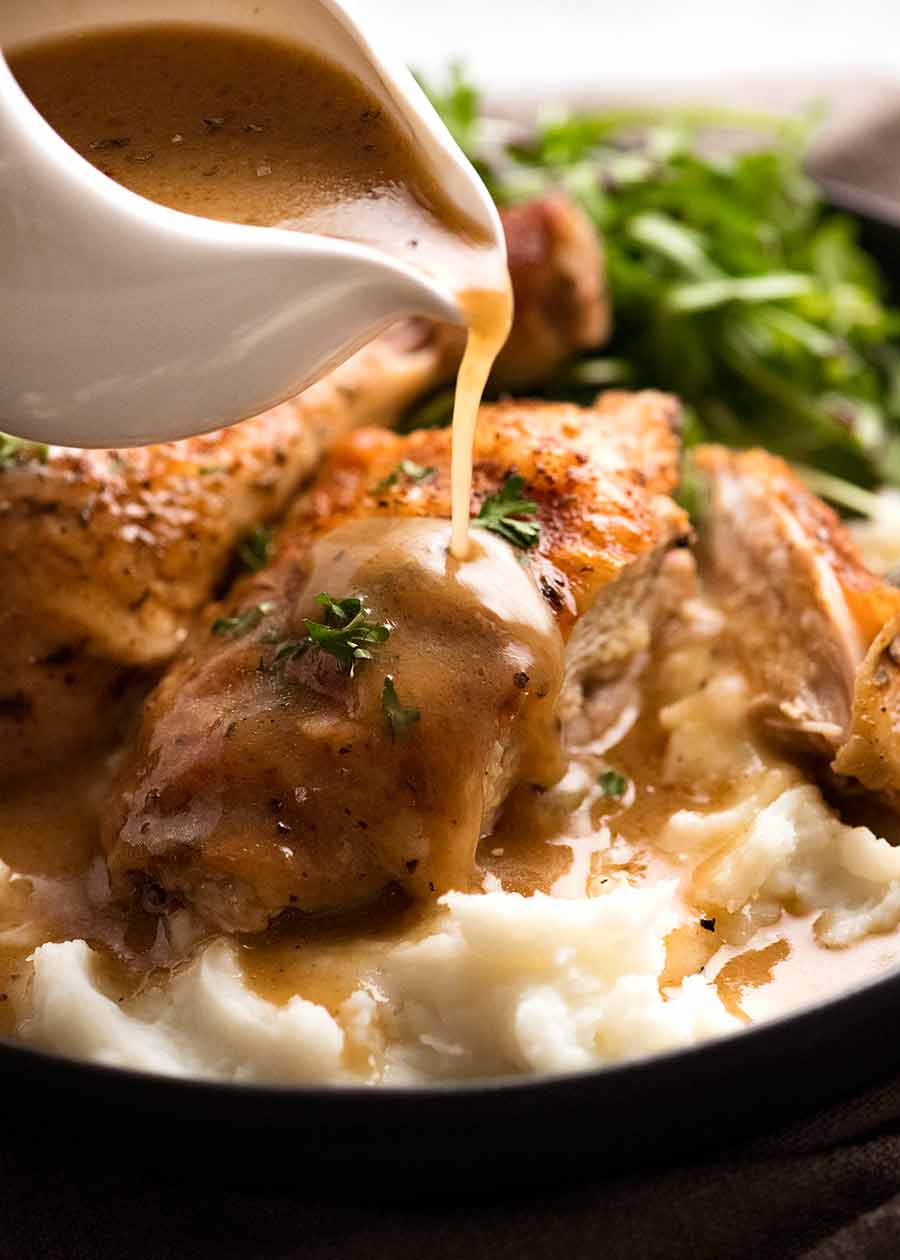 Pouring gravy over crispy baked chicken