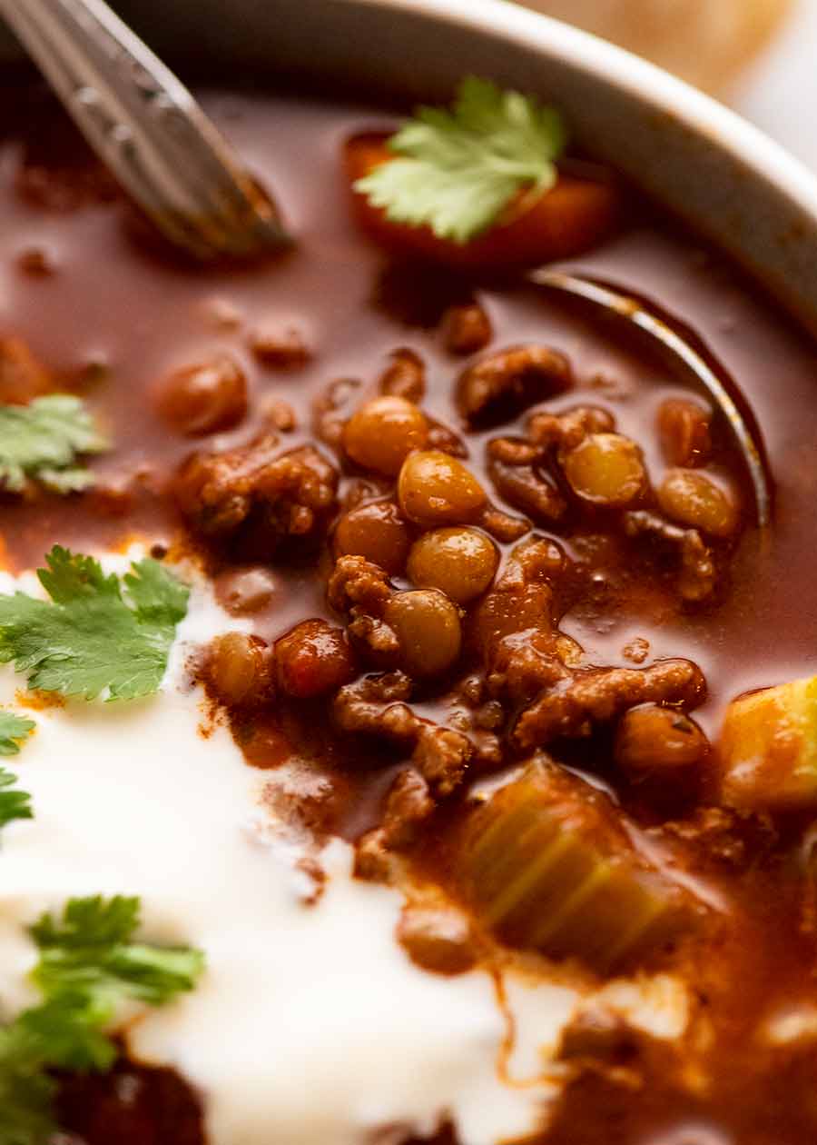 Close up of spoon scooping up Beef and Lentil Soup made with ground beef / beef mince