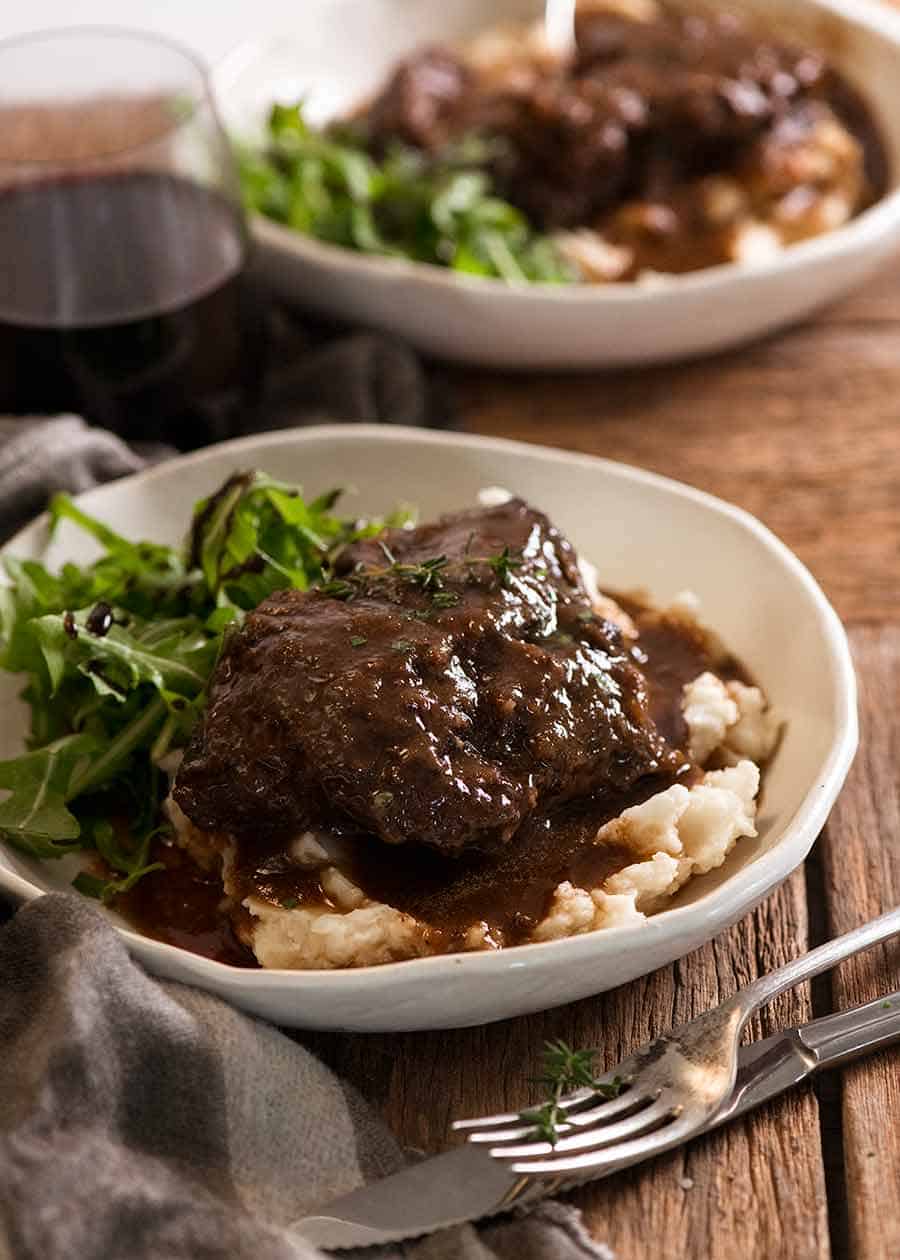 Slow Cooked Beef Cheeks with Red Wine Sauce on creamy mashed potato on a plate ready to be eaten