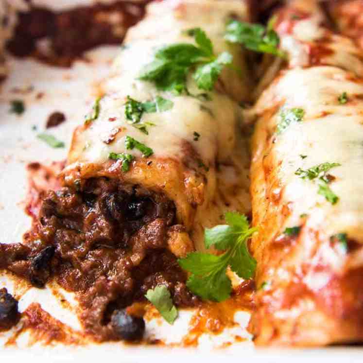 Close up of beef enchiladas in a baking dish, fresh out of the oven