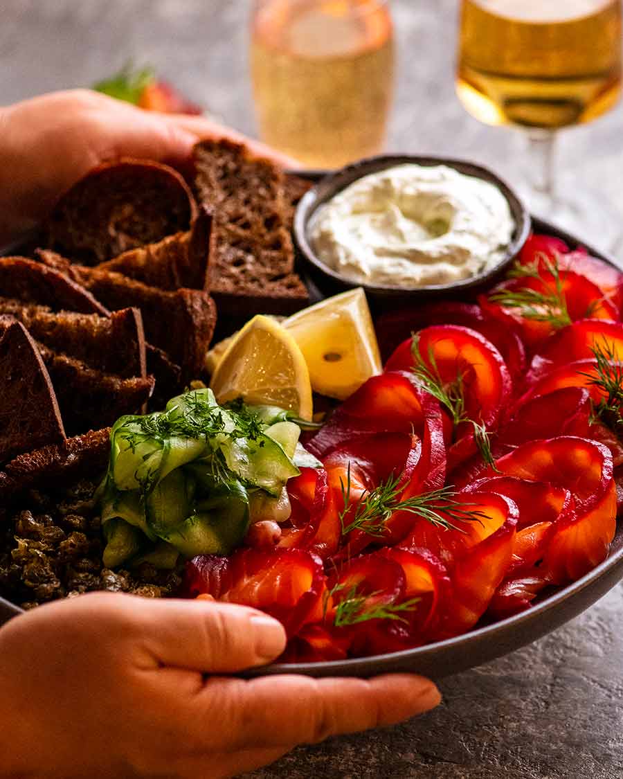 Platter of Beetroot Cured Salmon (Gin or Vodka, Salmon Gravlax) along with crackers and sauce for serving