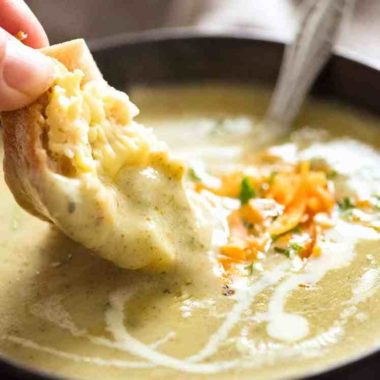 Warm crusty bread being dunked into creamy Easy Broccoli Soup