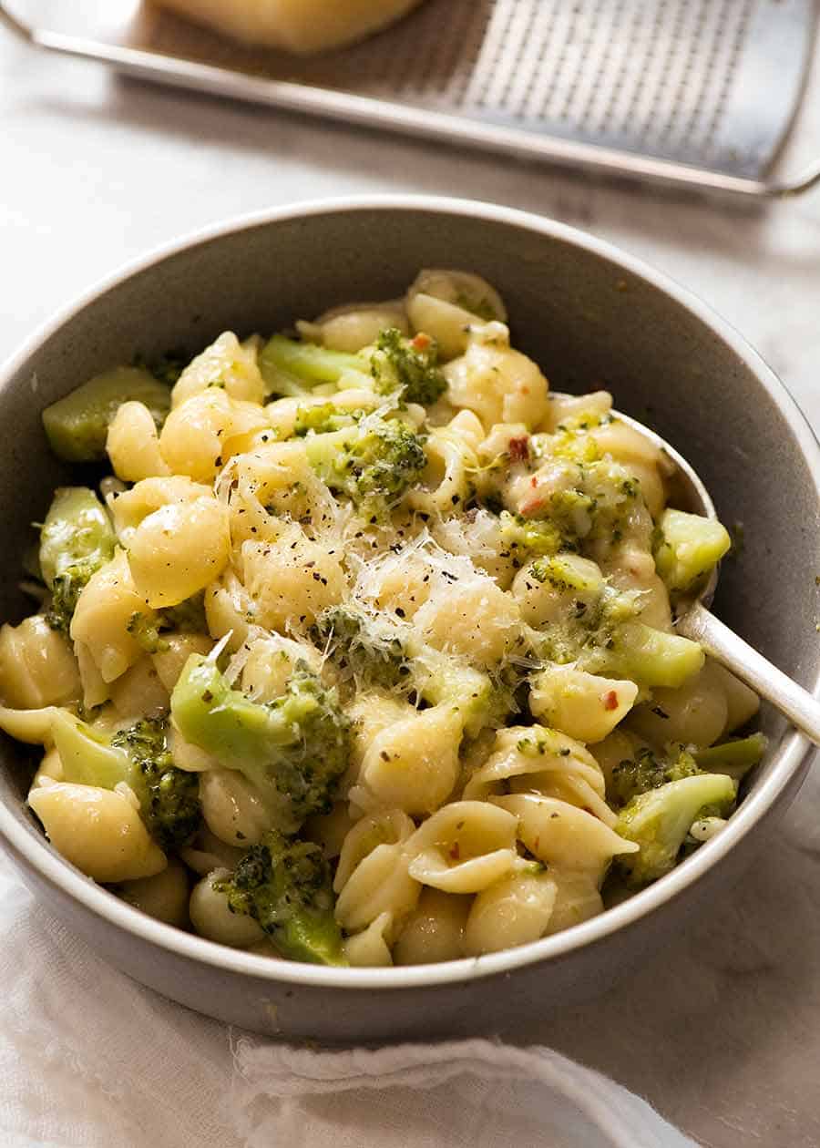 Cheesy broccoli pasta in a rustic blue bowl, ready to be eaten