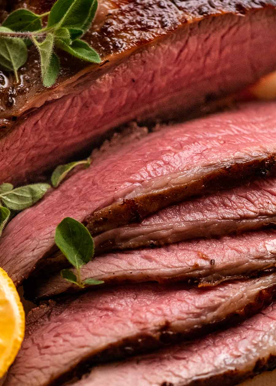 Close up of pink juicy slices of Greek Butterflied Lamb Leg