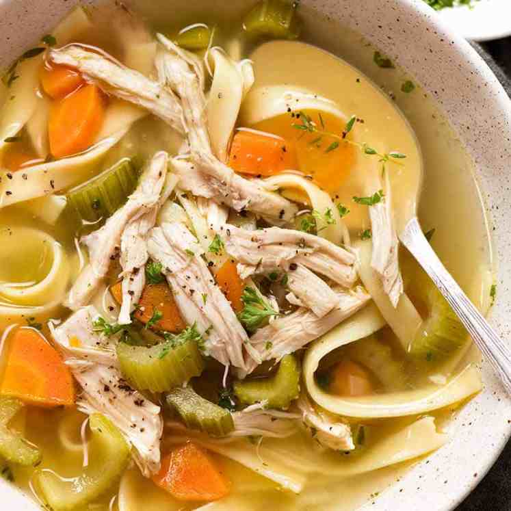 Overhead photo of Chicken Noodle Soup from scratch (whole chicken) in a bowl, ready to be eaten