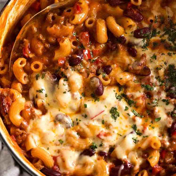 Chili Mac in a white cast iron pot, fresh off the stove ready to be served