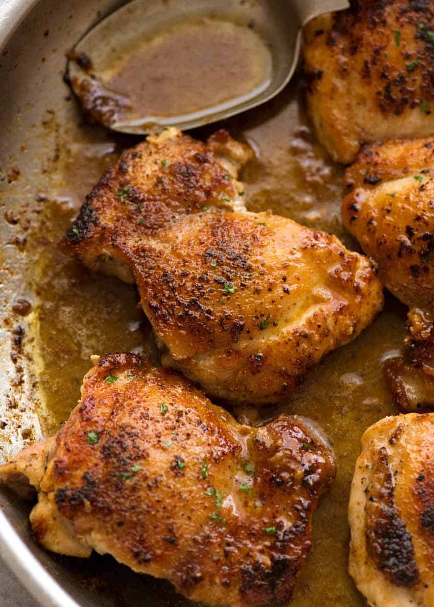 Close up of Crispy Garlic Chicken Thighs in a skillet with garlic butter sauce, fresh off the stove