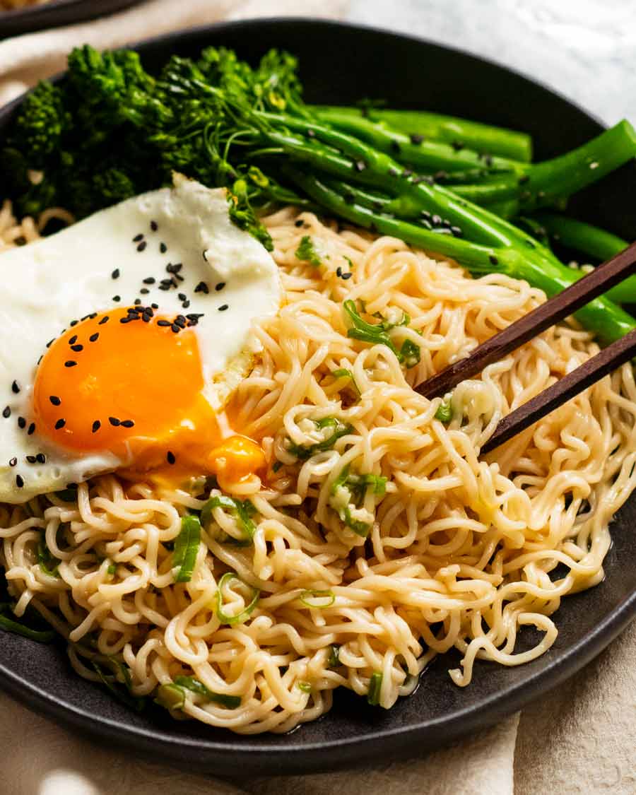 Bowl of Garlic Noodles with fried egg and broccolini