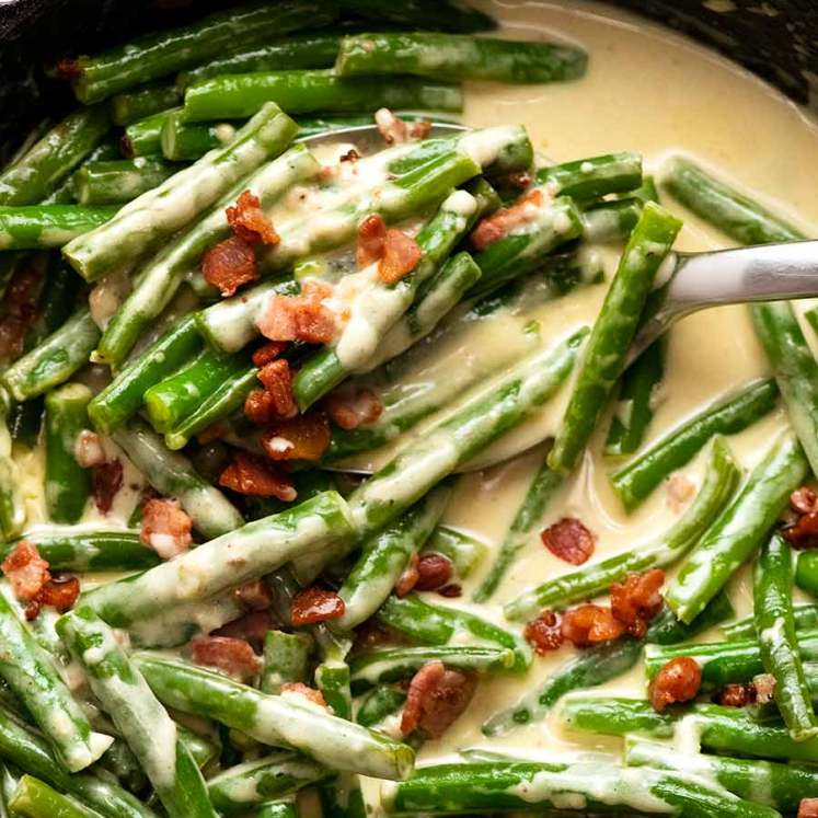 Close up overhead photo of Green beans in creamy parmesan sauce with bacon, fresh off the stove ready to be served