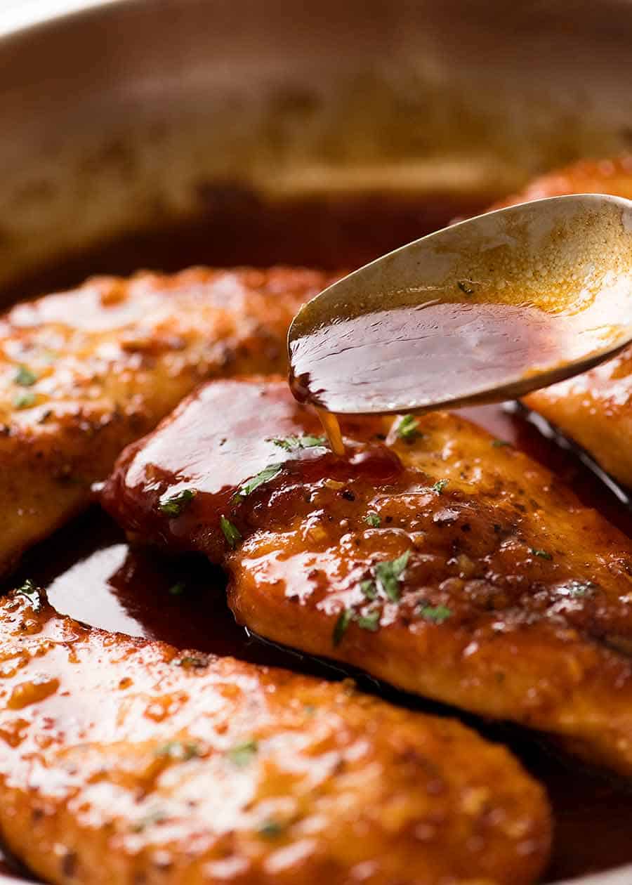 Spoon drizzling Honey Garlic Sauce over Chicken breast