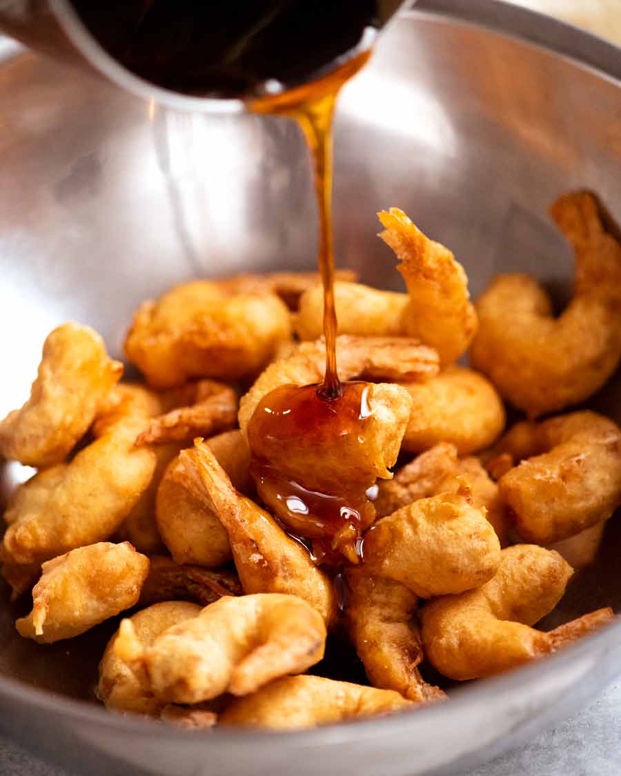 Pouring honey sauce over Honey Prawns