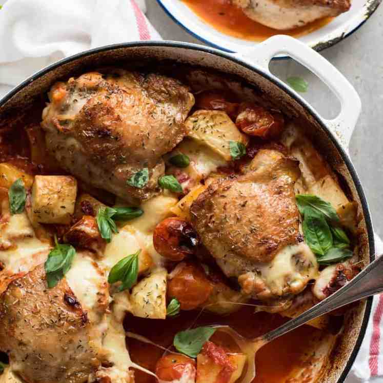 Baked Italian Chicken with Potatoes in a white casserole dish, fresh out of the oven ready for serving.