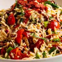 Pile of Italian risoni/ orzo salad with crispy salami bits