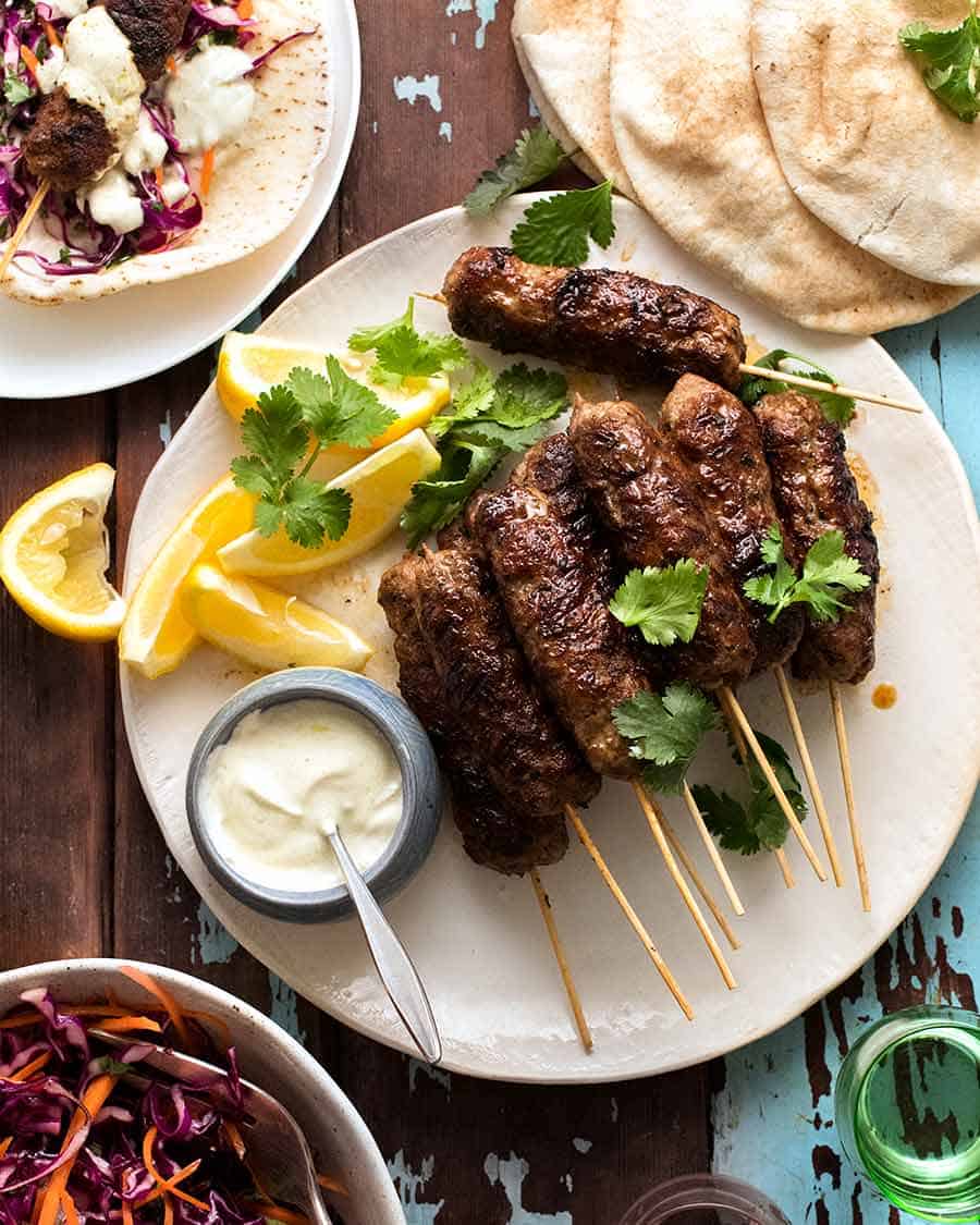 Lamb Koftas on a platter served with pita bread, minted cabbage salad and yogurt sauce