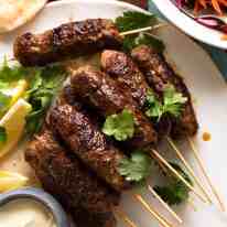 Lamb Koftas on a platter, ready to stuff into pita bread with minted salad and yogurt sauce