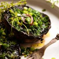 Roasted Large Mushrooms with Green Onion Thyme Butter on a plate, ready to be eaten