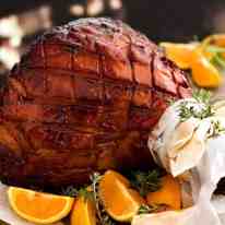 Maple Ham Glaze - glazed ham om a platter, ready to be carved. The most incredible baked ham ever!