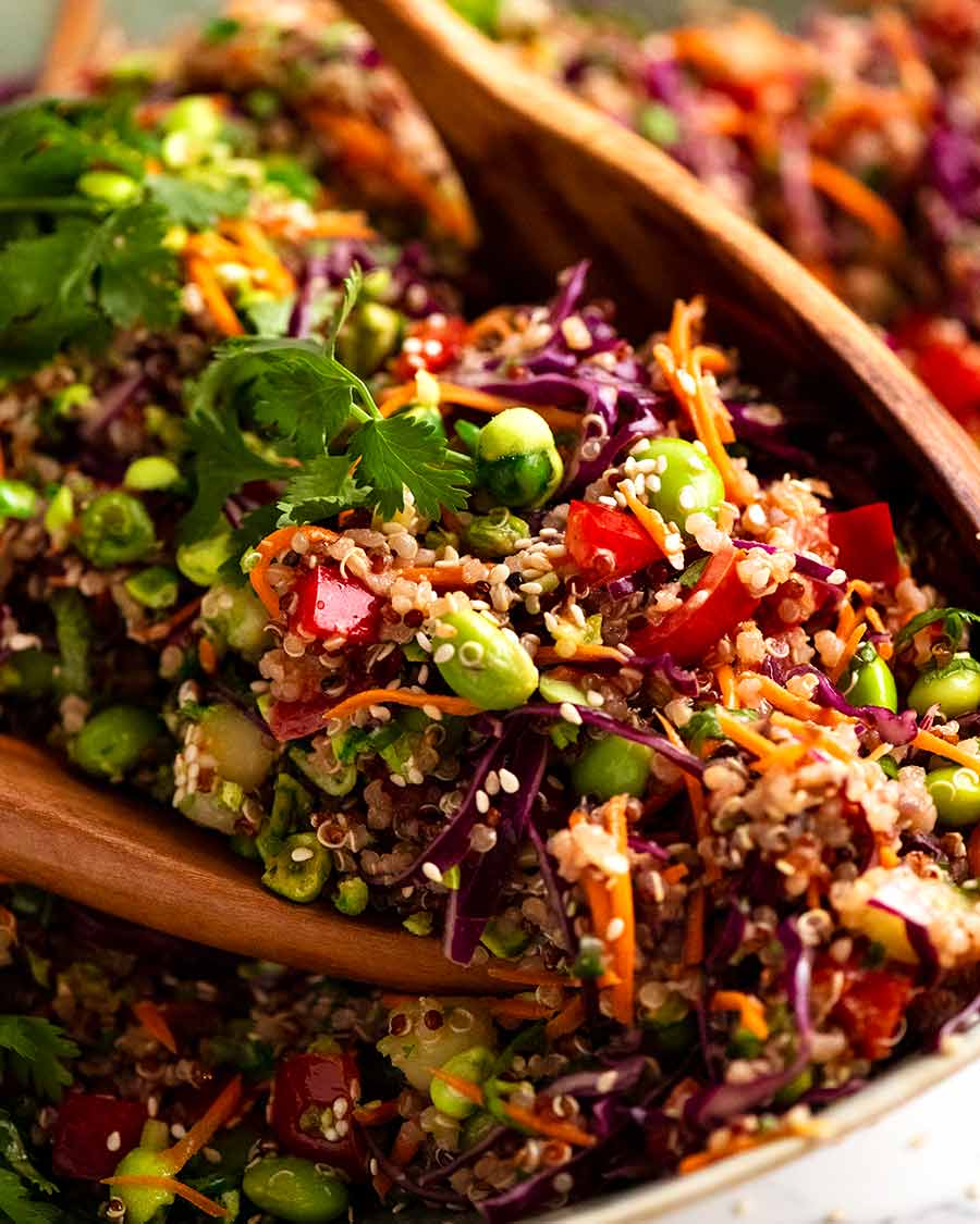 Close up of wooden spoons scooping up Quinoa Salad