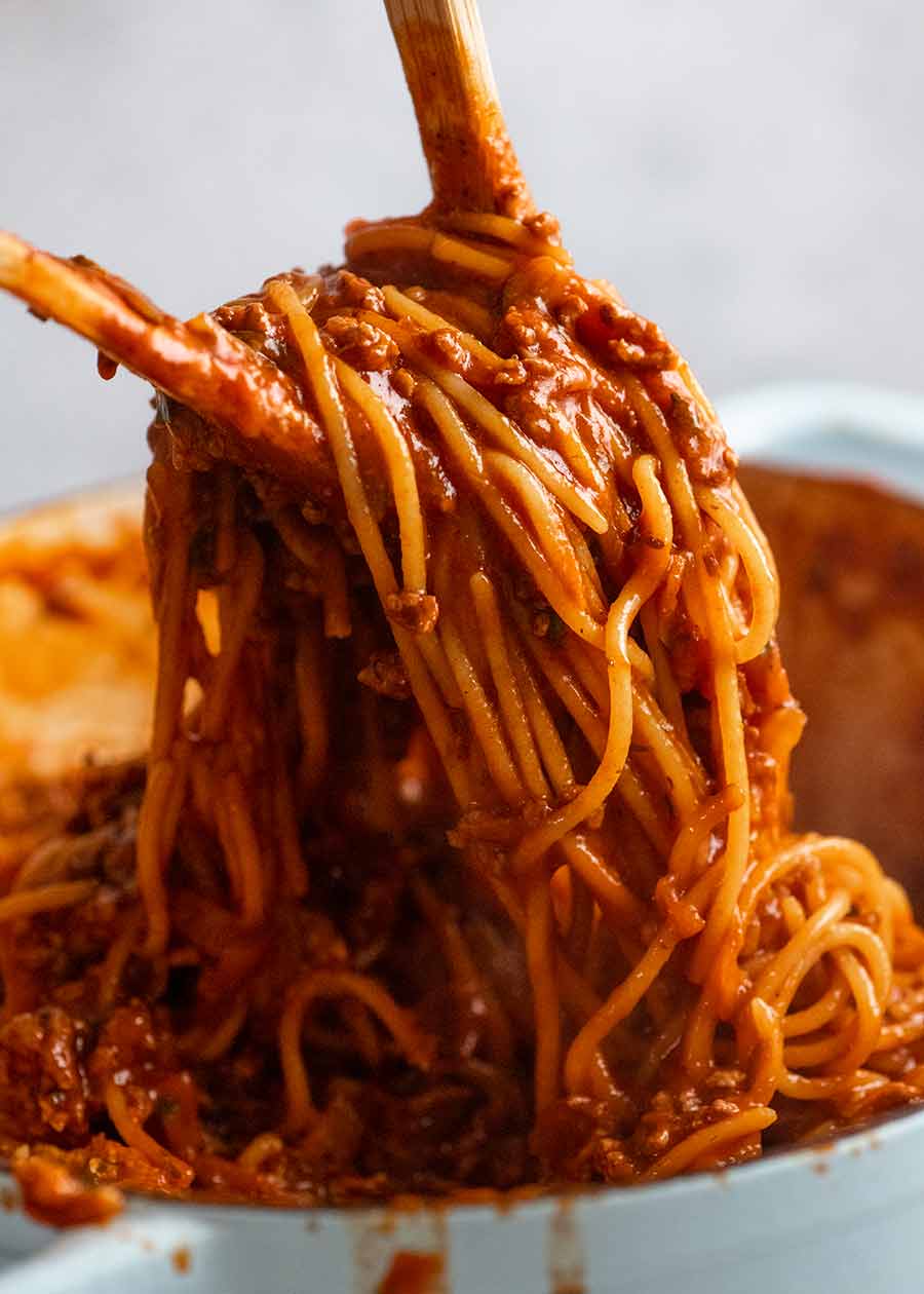 Using two wooden spoons to serve One Pot Pasta Bolognese