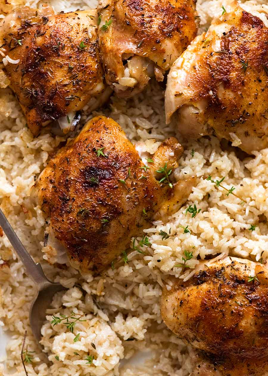 Oven Baked Chicken and Rice in a white baking pan, fresh out of the oven