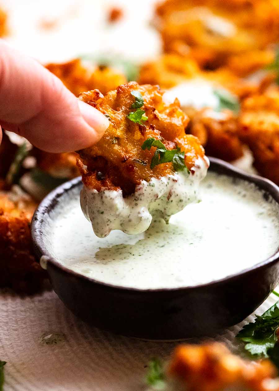 Dipping Pakora in Yogurt Mint Sauce