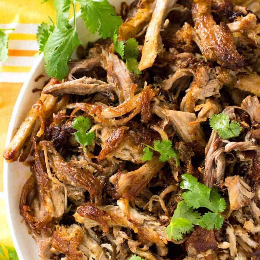 Close up overhead shot of crispy golden and juicy Pork Carnitas .