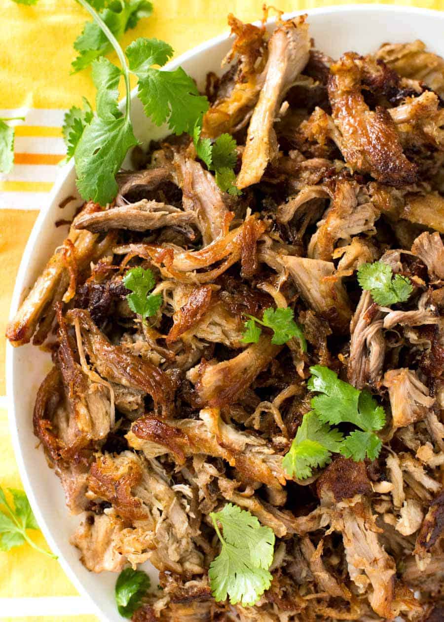 Overhead shot of crispy golden and juicy Pork Carnitas .