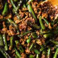 Close up of Pork Stir Fry with Green Beans in a black skillet, fresh off the stove