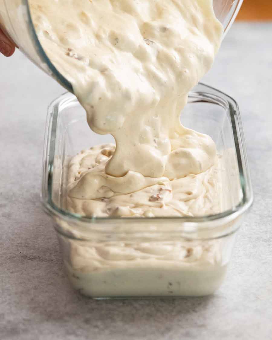 Pouring Rum raisin ice cream into ice cream container