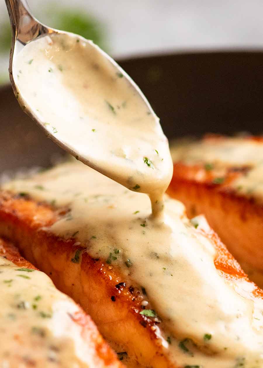 Drizzling cream Herb & Garlic Salmon Sauce over pan seared salmon