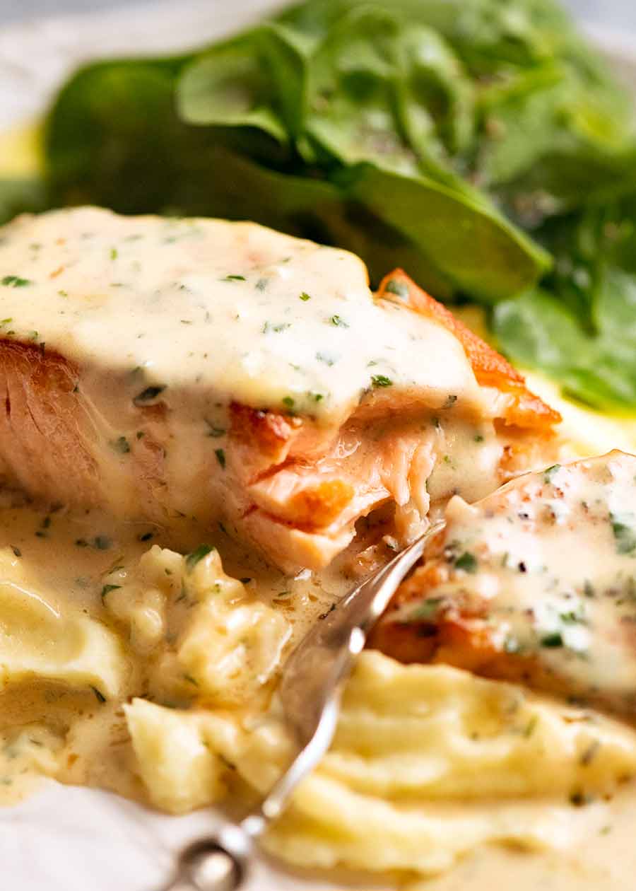 Fork cutting into Creamy Herb & Garlic Salmon Sauce