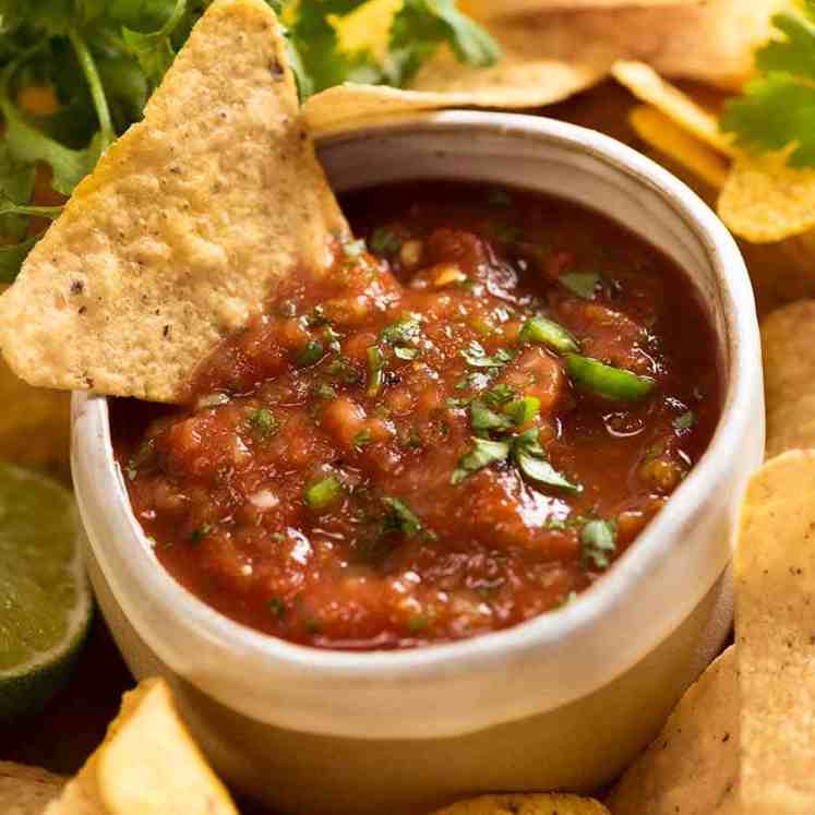 Salsa recipe for restaurant style salsa. Salsa in a ceramic bowl with corn chips.