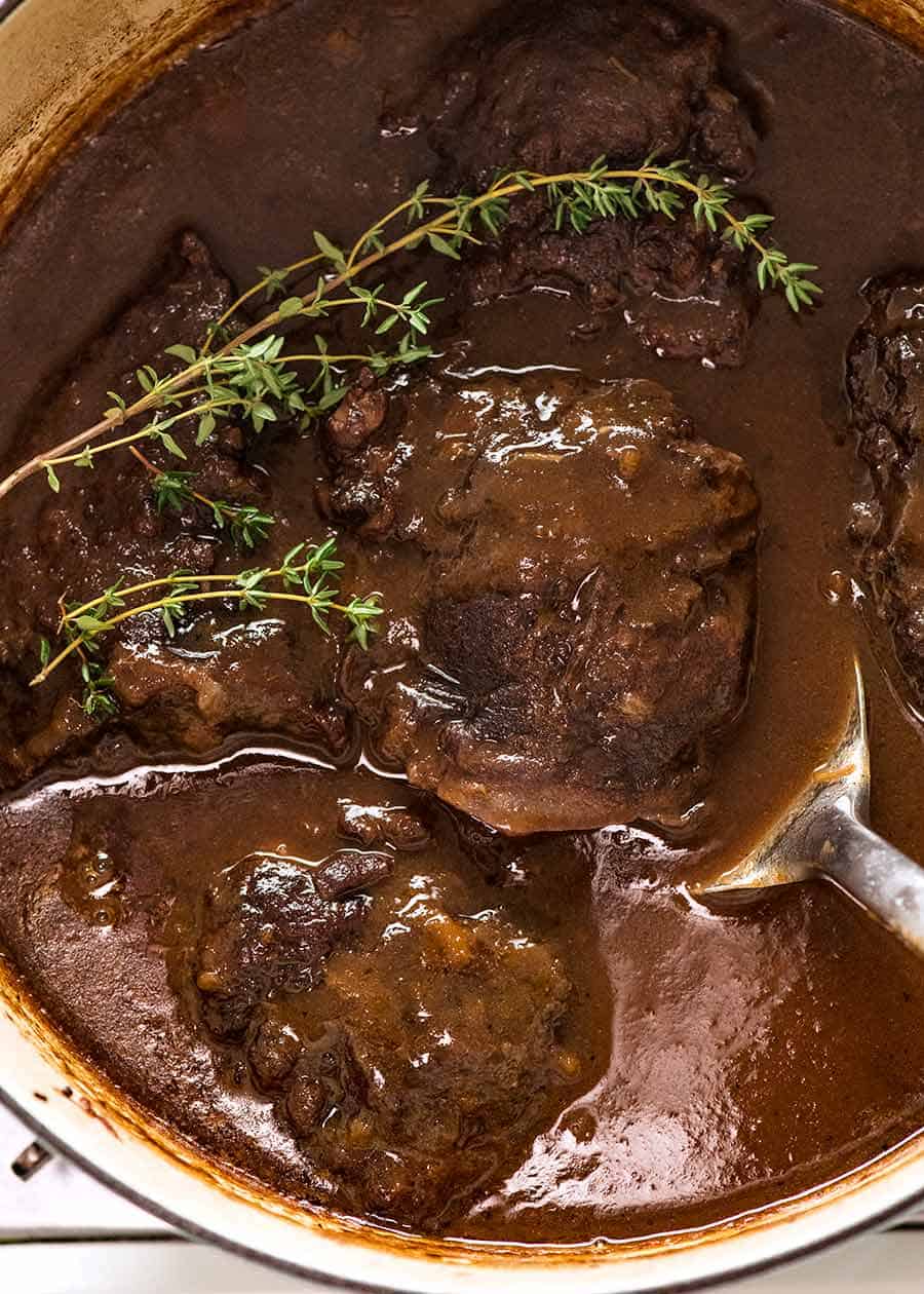 Overhead photo of Slow Cooked Beef Cheeks with Red Wine Sauce in a pot, fresh off the stove ready to be served.