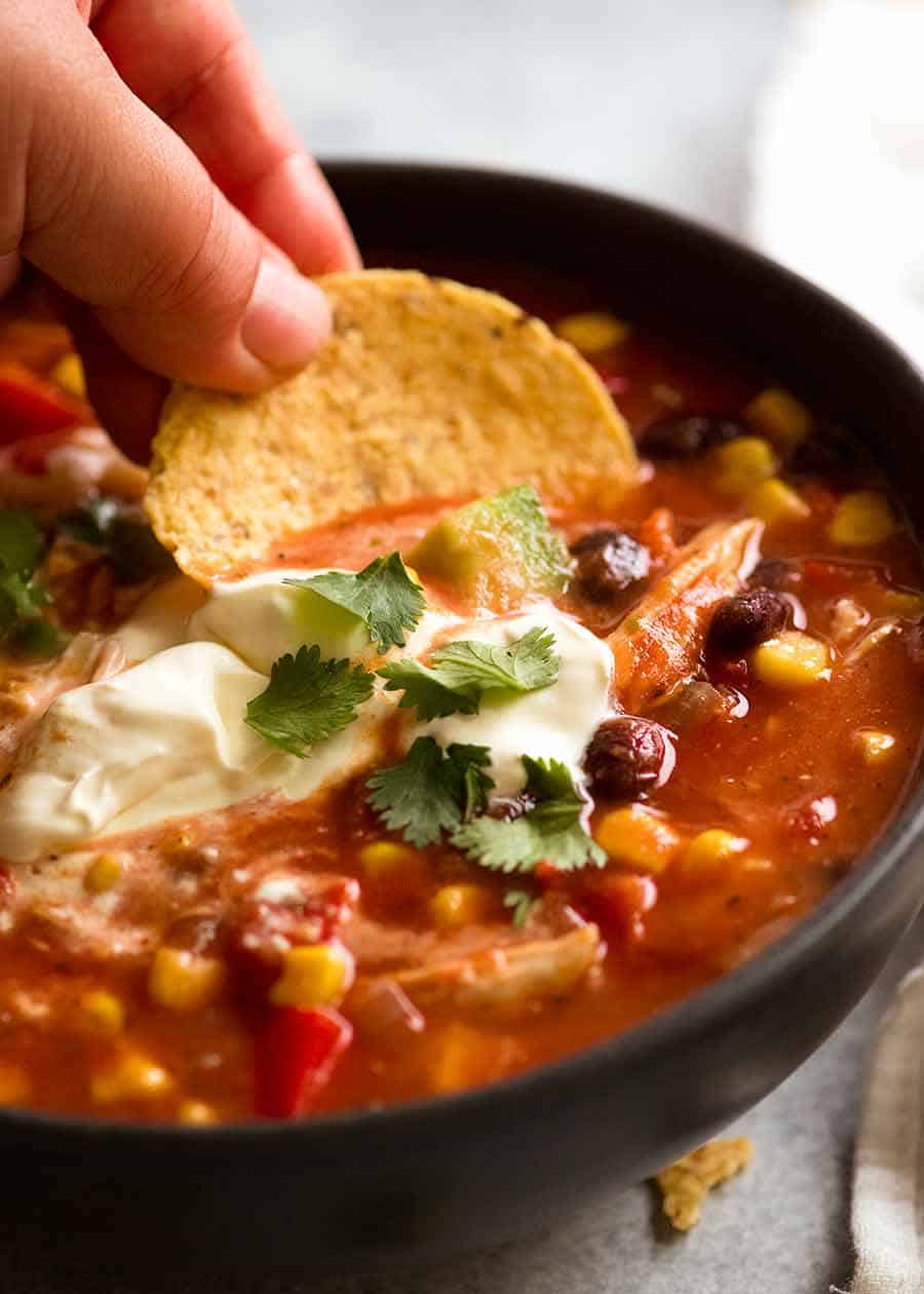 Close up of corn chip being inked into Mexican Chicken Soup