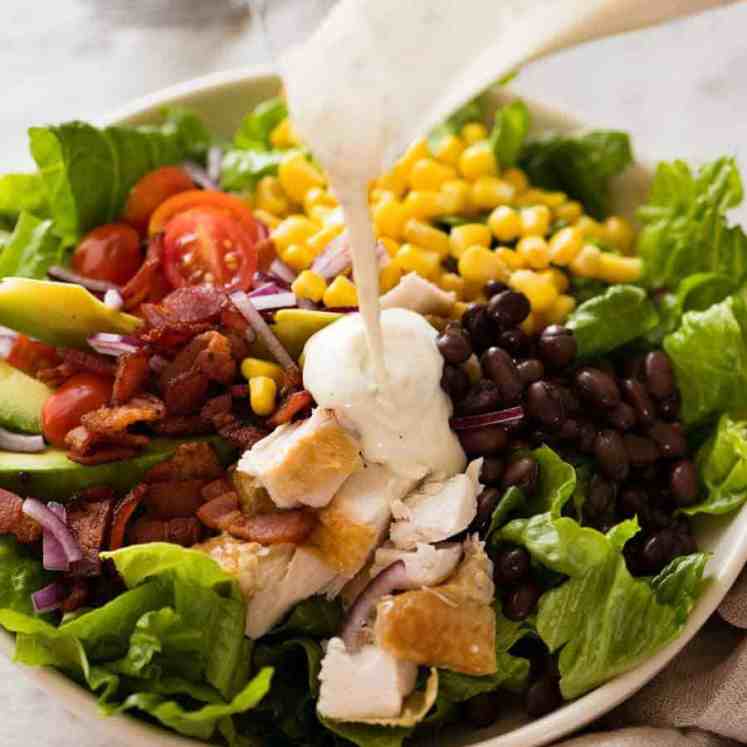 Yogurt Ranch Dressing being poured over SouthWest Chicken Salad