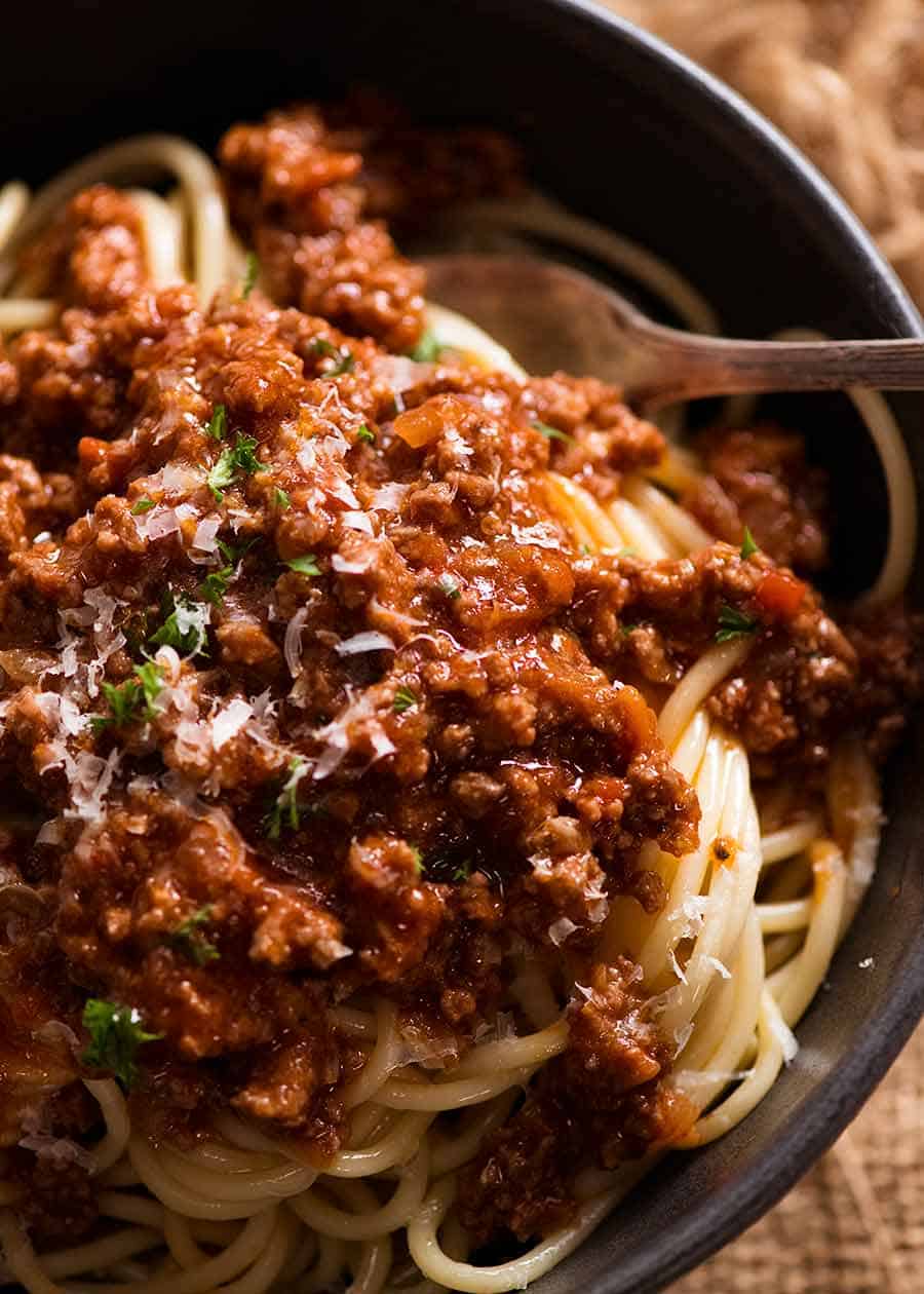 Close up of Spaghetti Bolgonese in a rustic black bowl, ready to be eaten