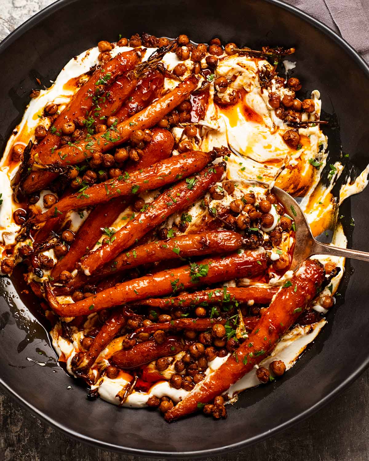 Spicy maple roasted carrots with crispy chickpeas with yogurt sauce on a plate